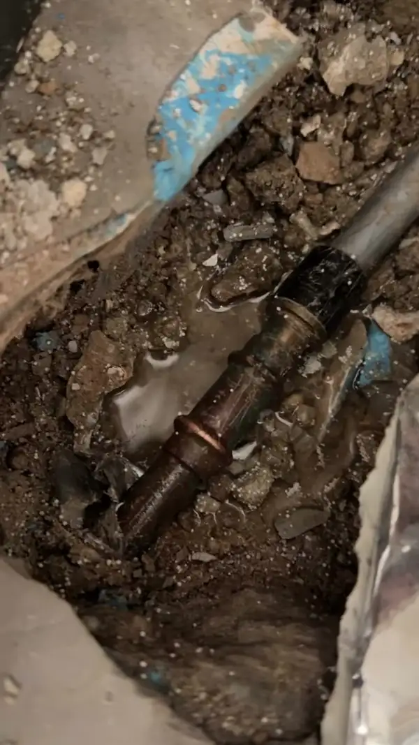 Freigelegte Wasserleitung in einem aufgestemmten Boden
